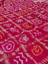 Apink saree with a bandhani pattern and gota patti work.