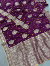 A purple Dola silk saree with detailed Zari weaving work and a Banarasi style pattern, including a wide border with similar ornate design.