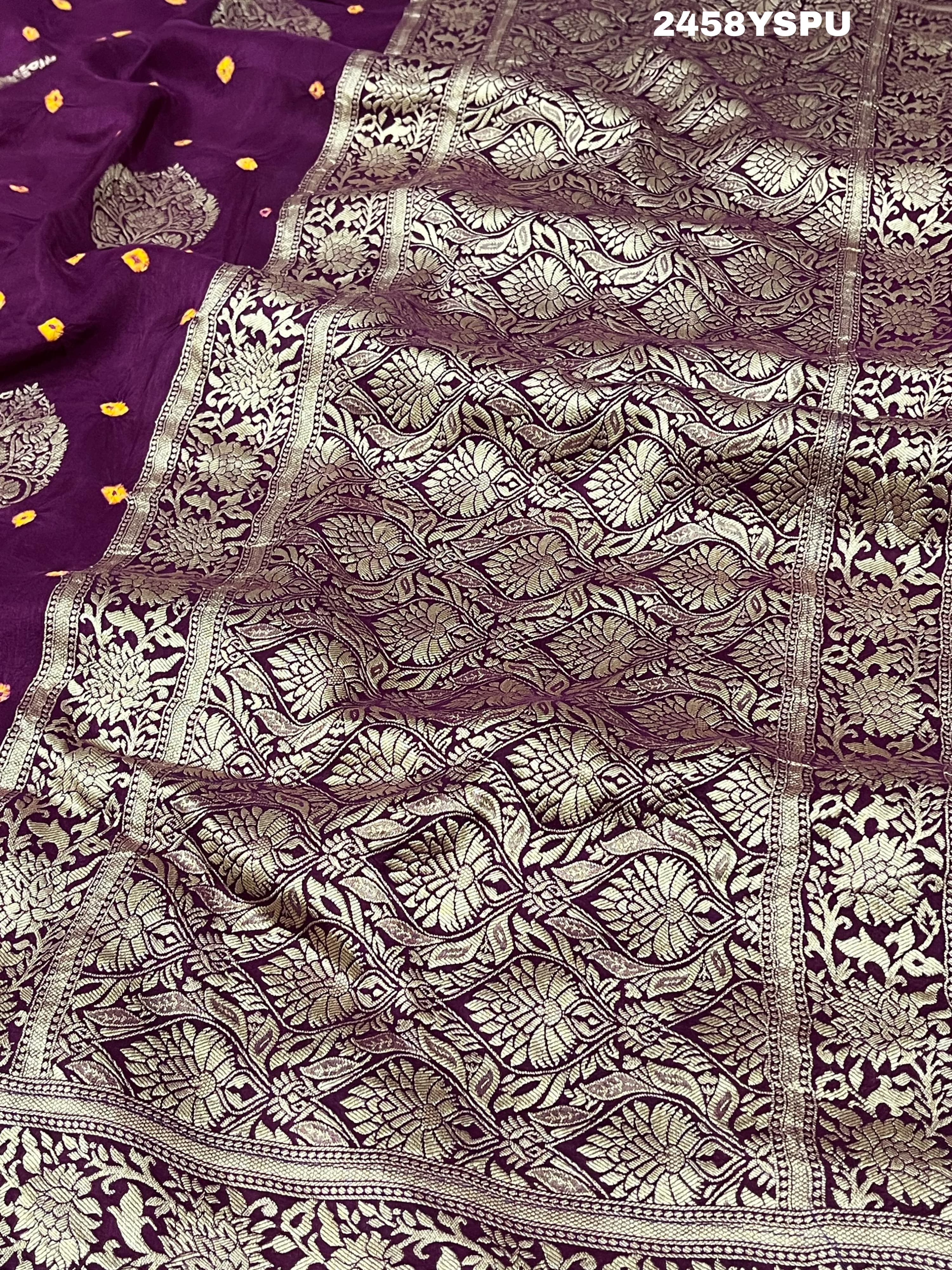 A purple Dola silk saree with detailed Zari weaving work and a Banarasi style pattern, including a wide border with similar ornate design.