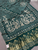 A green modal silk saree with bandhani style patterns and gotapatti work