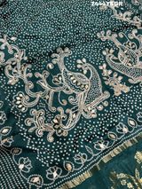 A green modal silk saree with bandhani style patterns and gotapatti work