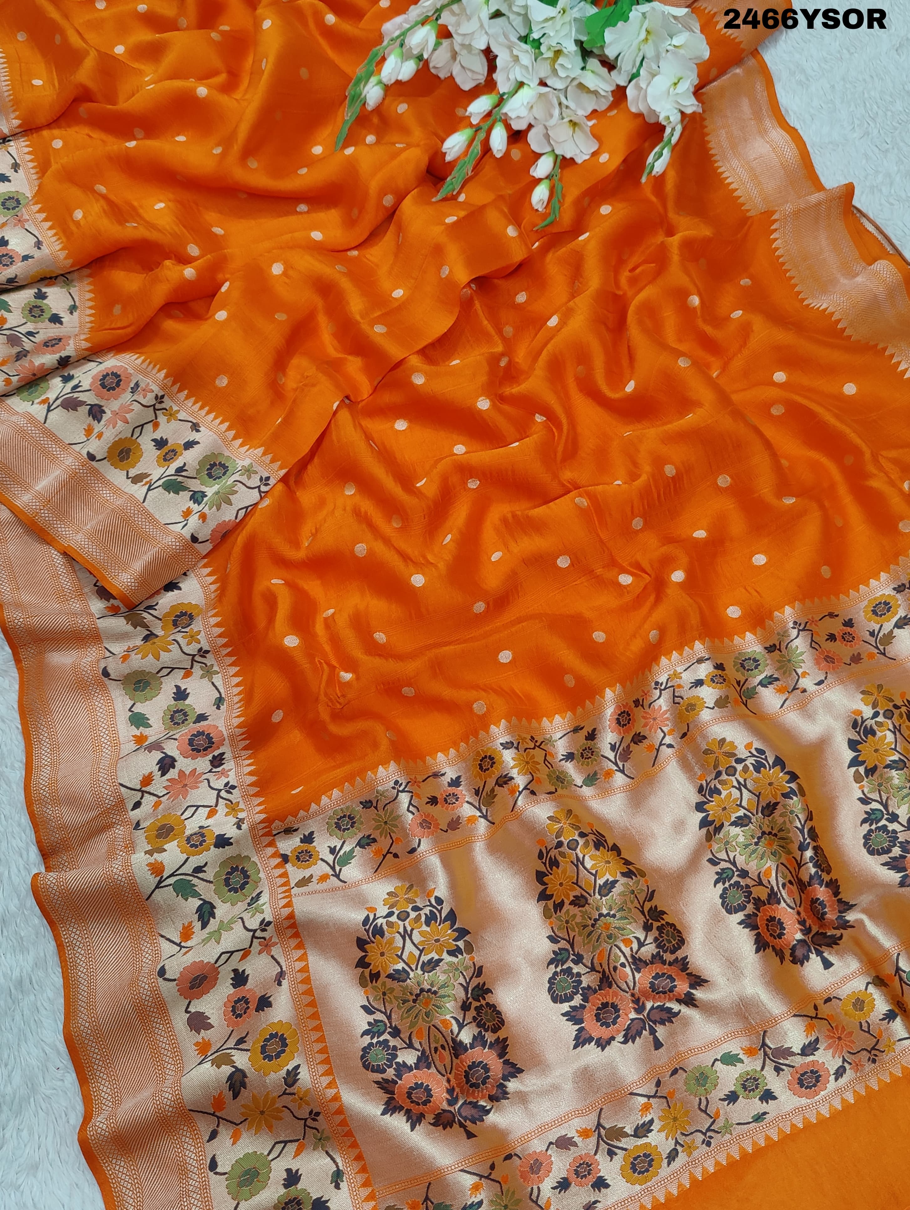 An orange Banarasi silk saree with floral printed style and zari weaving work