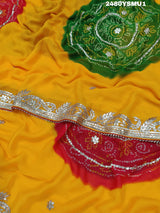 A saree with bandhani style patterns in orange and red colors, featuring detailed gotapatti work.