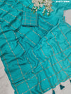 A sea green color saree with geometric pattern and pittan work