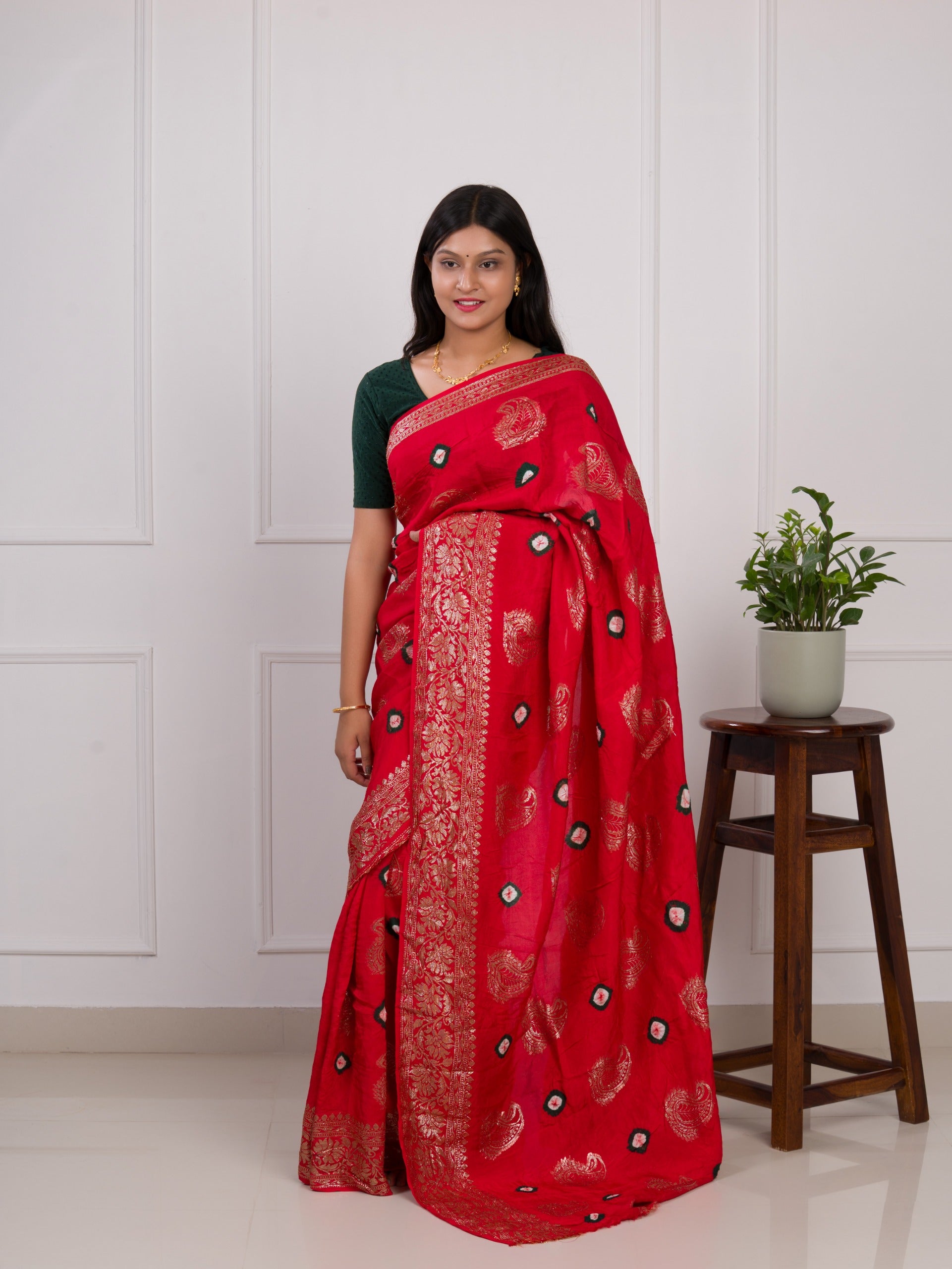 A red saree with green patterns withDola Silk Bandhani Zari Weaving Work 