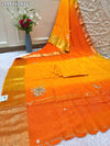 By Orange saree with gold border and floral embroidery