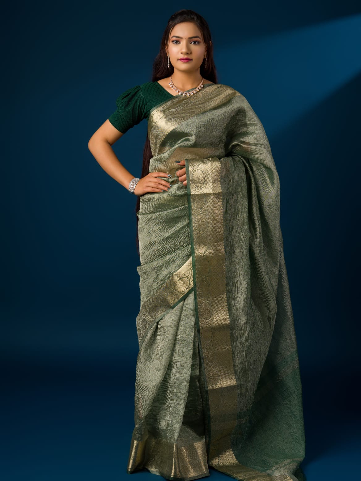 A green and gold Banarasi style saree with zari border.
