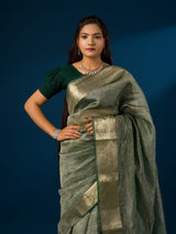A green and gold Banarasi style saree with zari border.