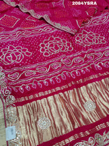 A pink and red bandhani style saree with gotapatti work
