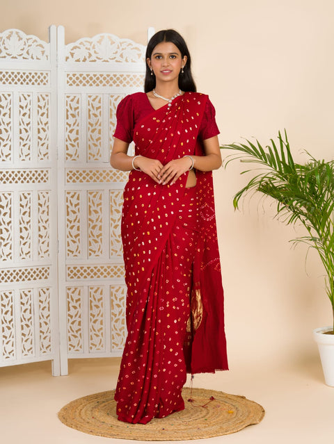 A red and golden bandhani silk saree with a geometric pattern and lagdi patola pallu.