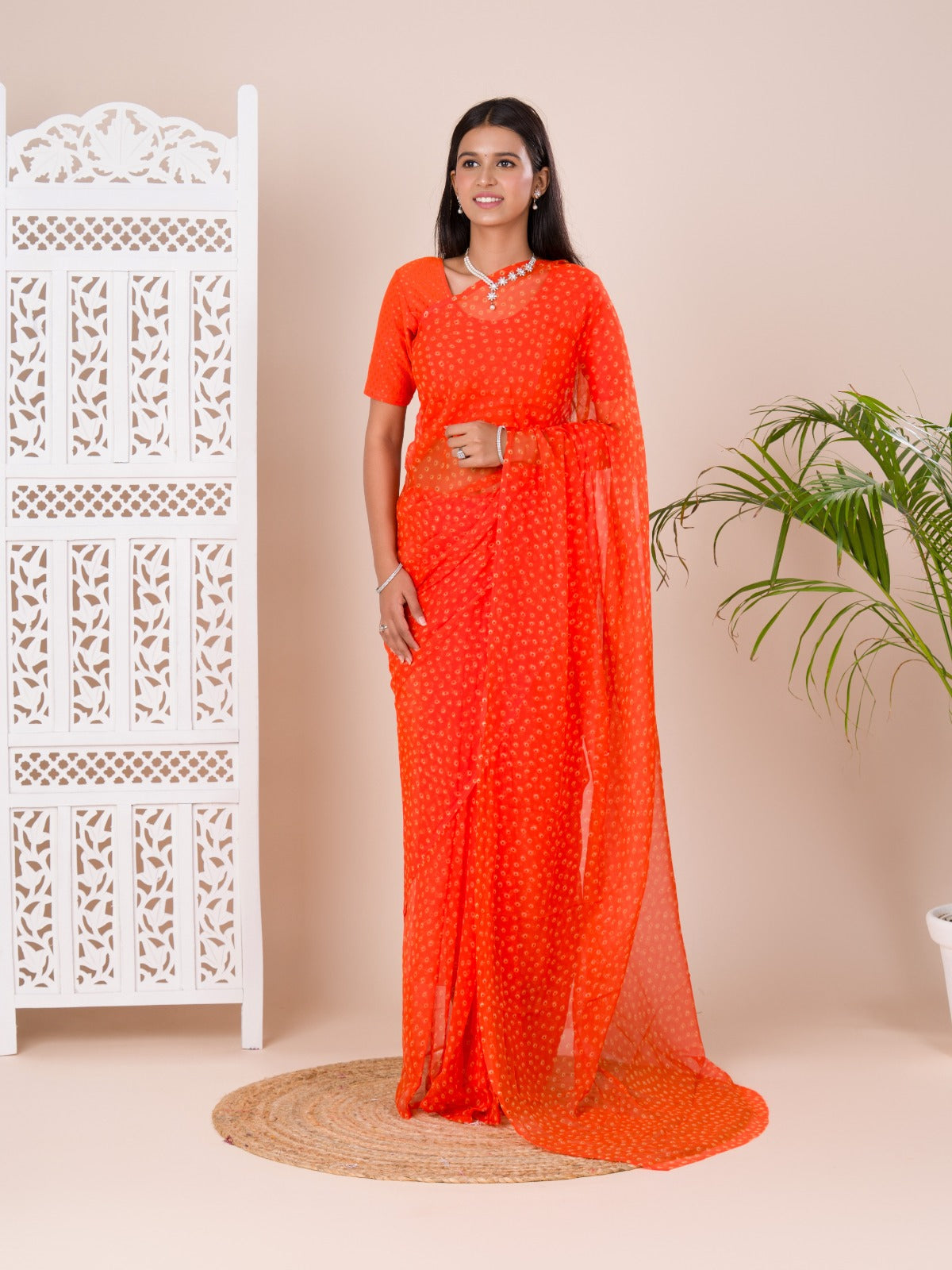 an orange chiffon saree with a bandhani pattern