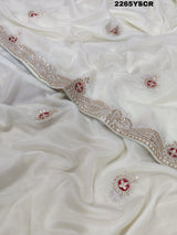 A cream-colored tissue silk saree with Bollywood-style embellishments and gotapatti work, including floral patterns and traditional border designs.