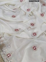 A cream-colored tissue silk saree with Bollywood-style embellishments and gotapatti work, including floral patterns and traditional border designs.