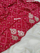 A cream-colored tissue silk saree with Bollywood-style embellishments and gotapatti work, including floral patterns and traditional border designs.