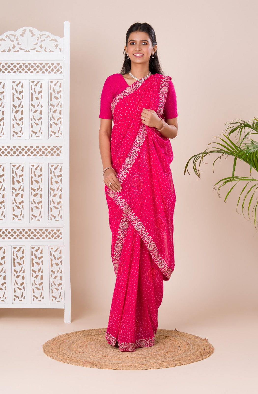 A pink saree with a bandhani pattern 