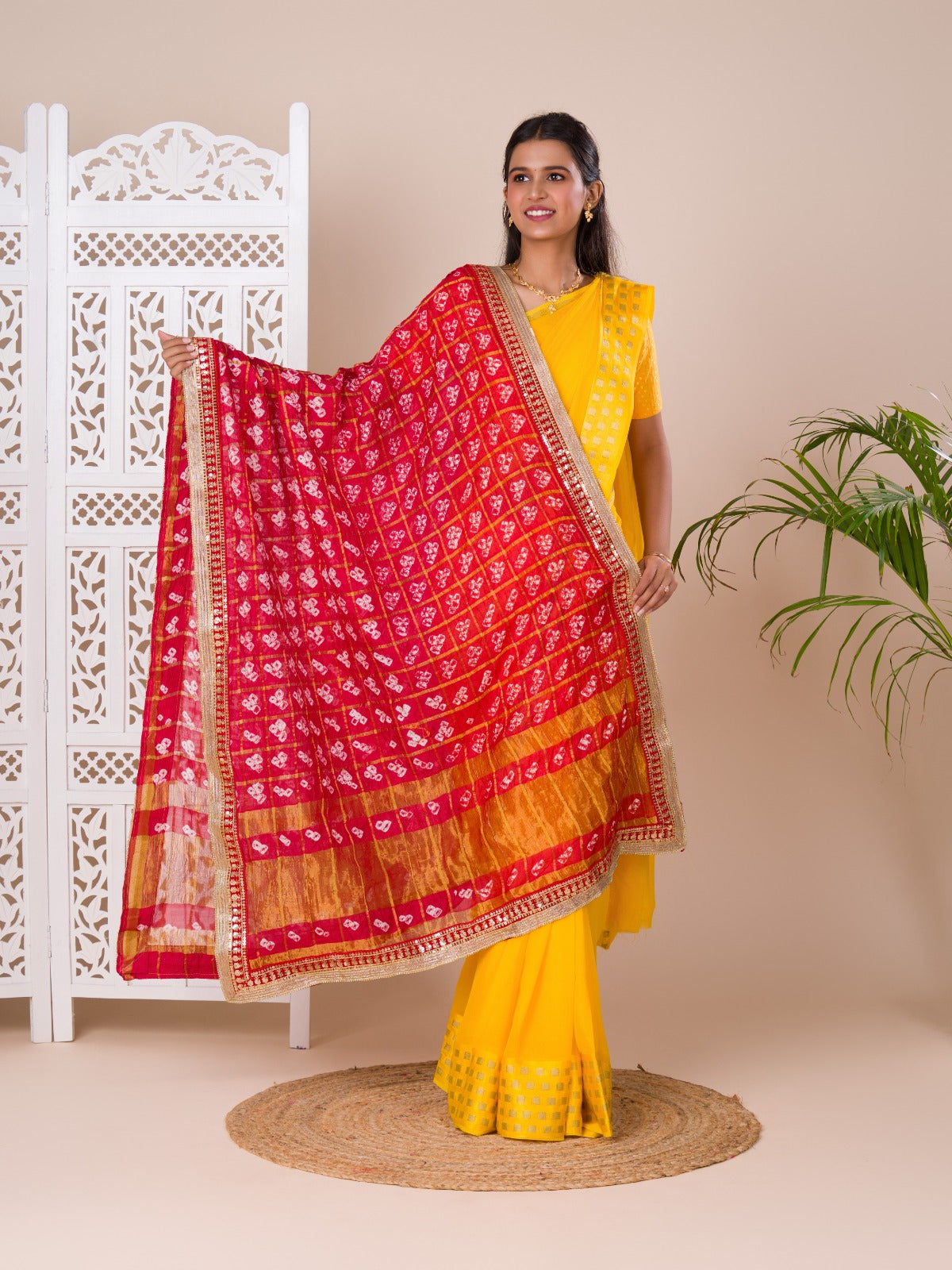 A traditional Rajasthani Bandhani Chunri Piliya Dupatta in red and yellow with a floral pattern
