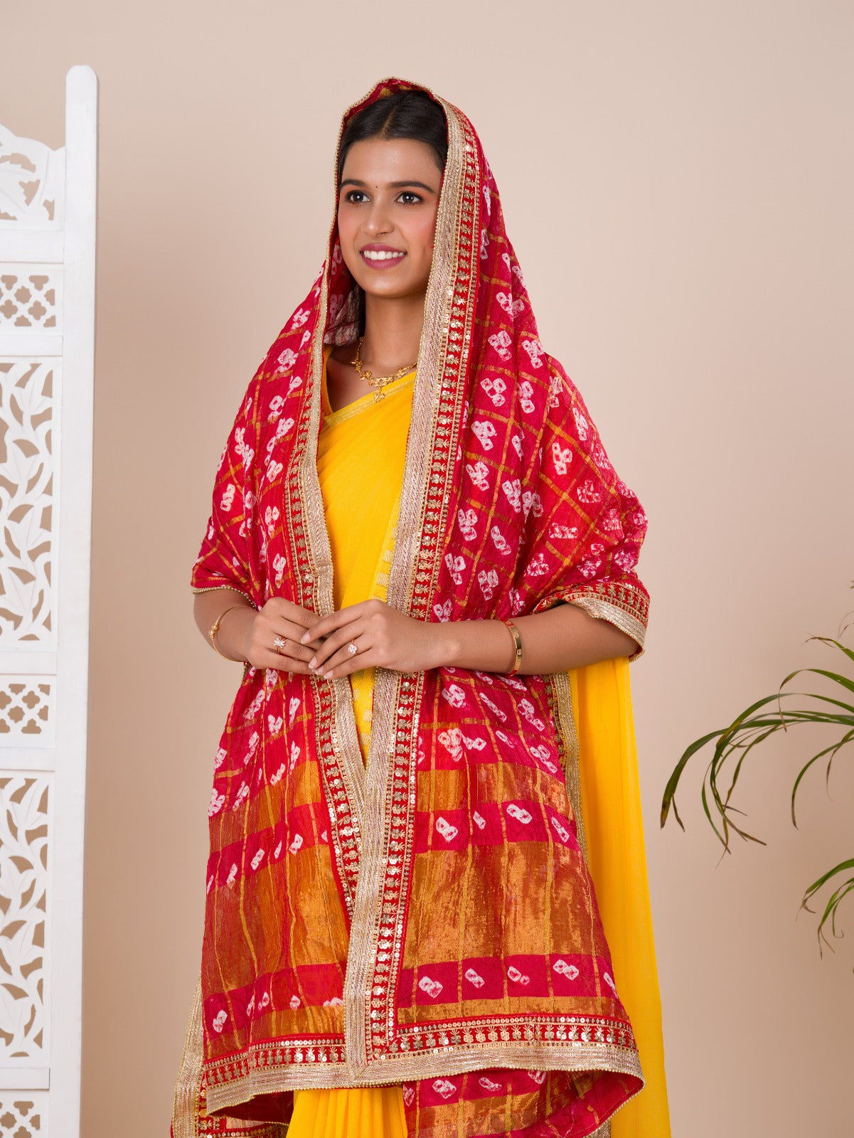 A traditional Rajasthani Bandhani Chunri Piliya Dupatta in red and yellow with a floral pattern