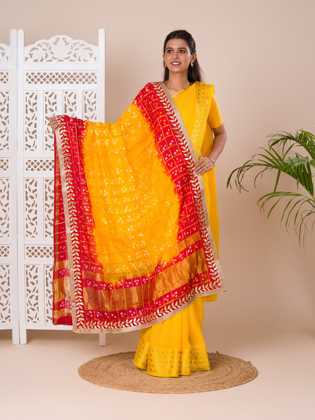A traditional Rajasthani Bandhani Chunri dupatta in yellow and red with a gotapatti border, paired with a matching gharchola silk pomcha.