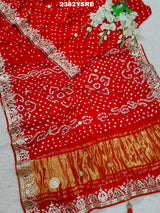 A red saree with white bandhani (dot) pattern and gotapatti border, 