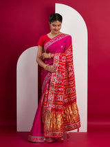 A pink saree with a red and gold border 