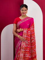 A pink saree with a red and gold border 