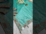 A sea green Banarasi silk saree with sequence embroidery work in a floral pattern and a border featuring a combination of sequins and beads.