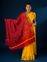 A woman wearing a traditional red and yellow dupatta with a geometric pattern 