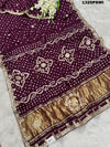 A purple and gold saree with gota patti work
