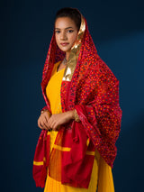 A woman wearing a traditional red and yellow dupatta with a geometric pattern 